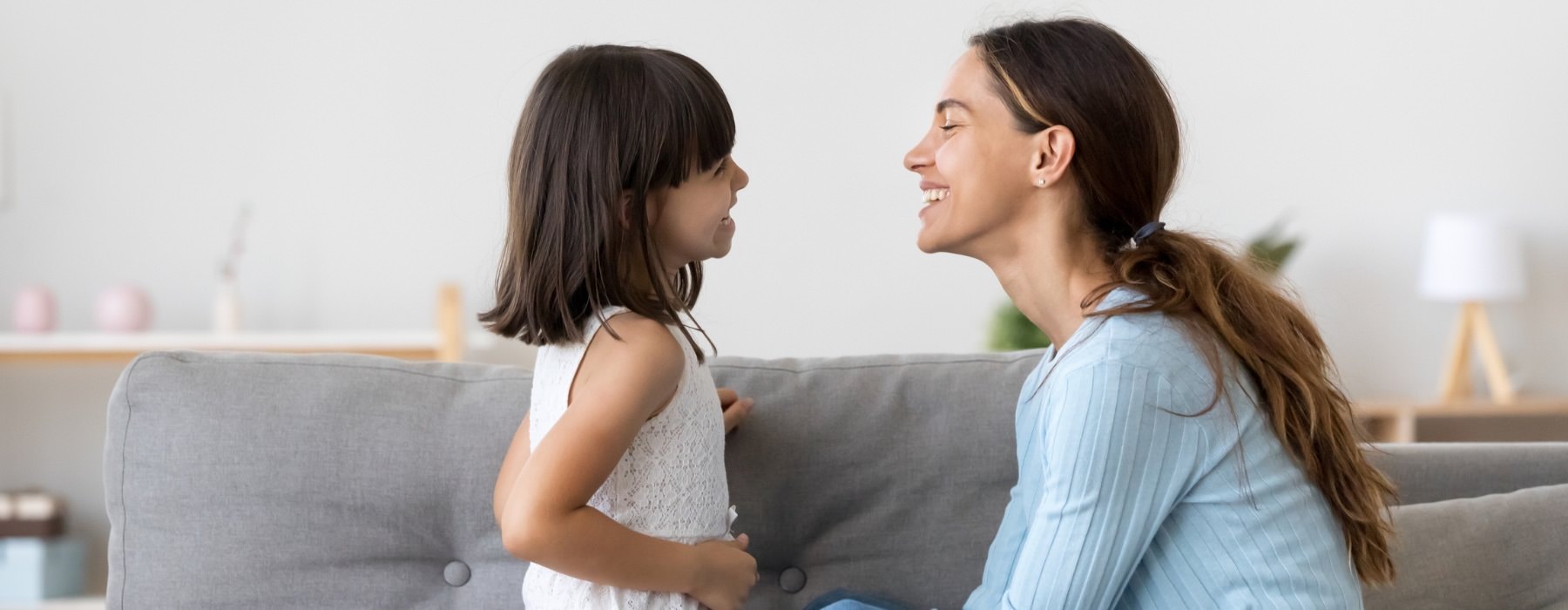 a mom and daughter smiling at each other